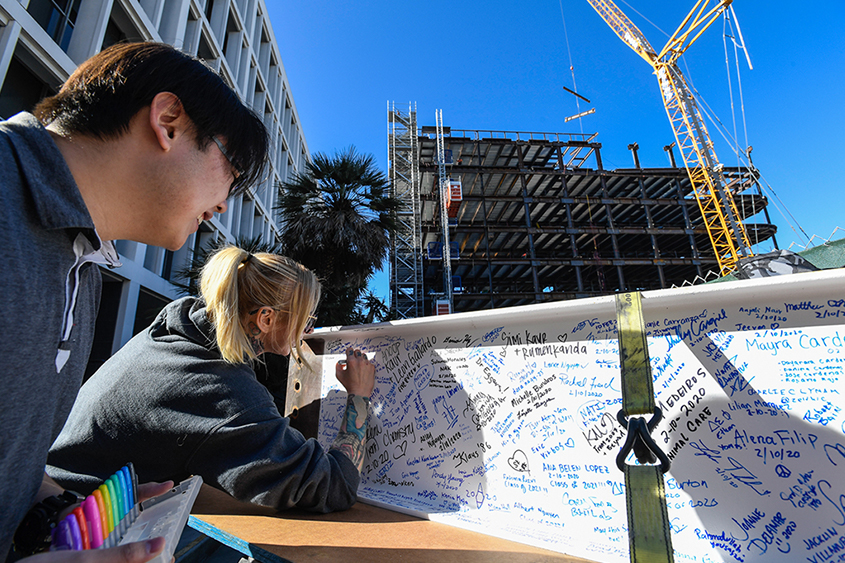 SJSU students signing the last beam for the ISB building.