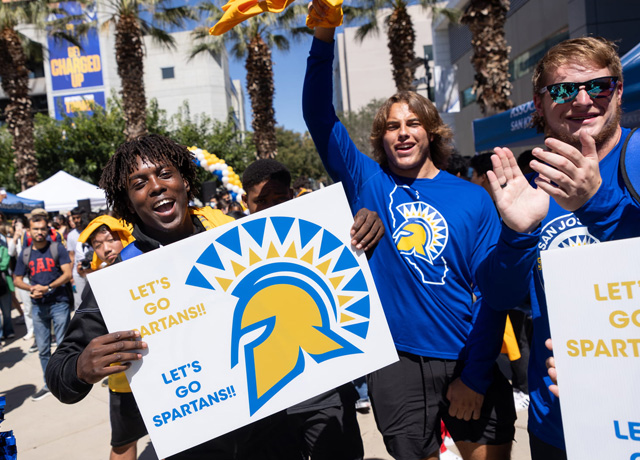 SJSU students celebrating with Go Spartans! signs.