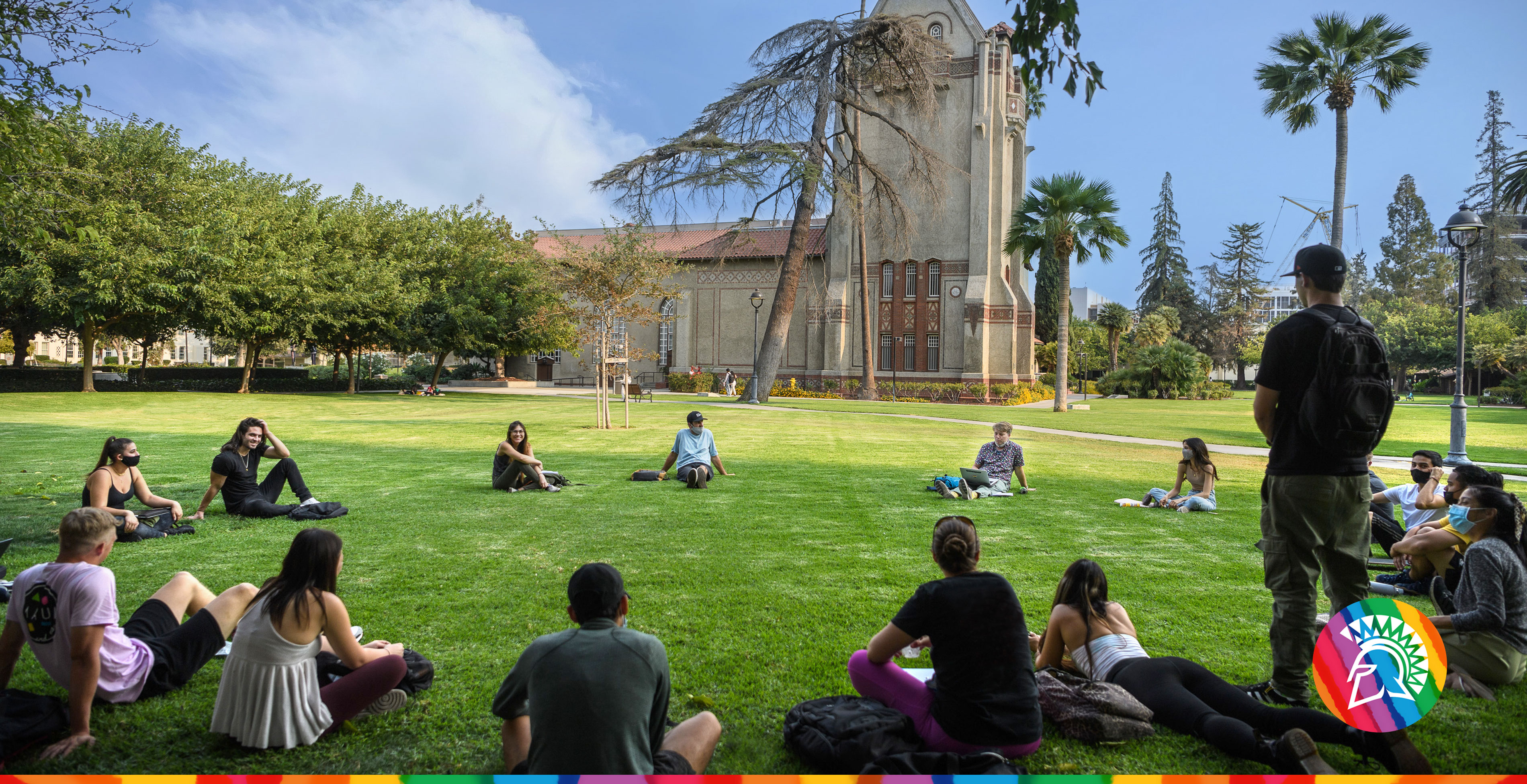SJSU students sit in a circle formation on a beautiful day on tower lawn.