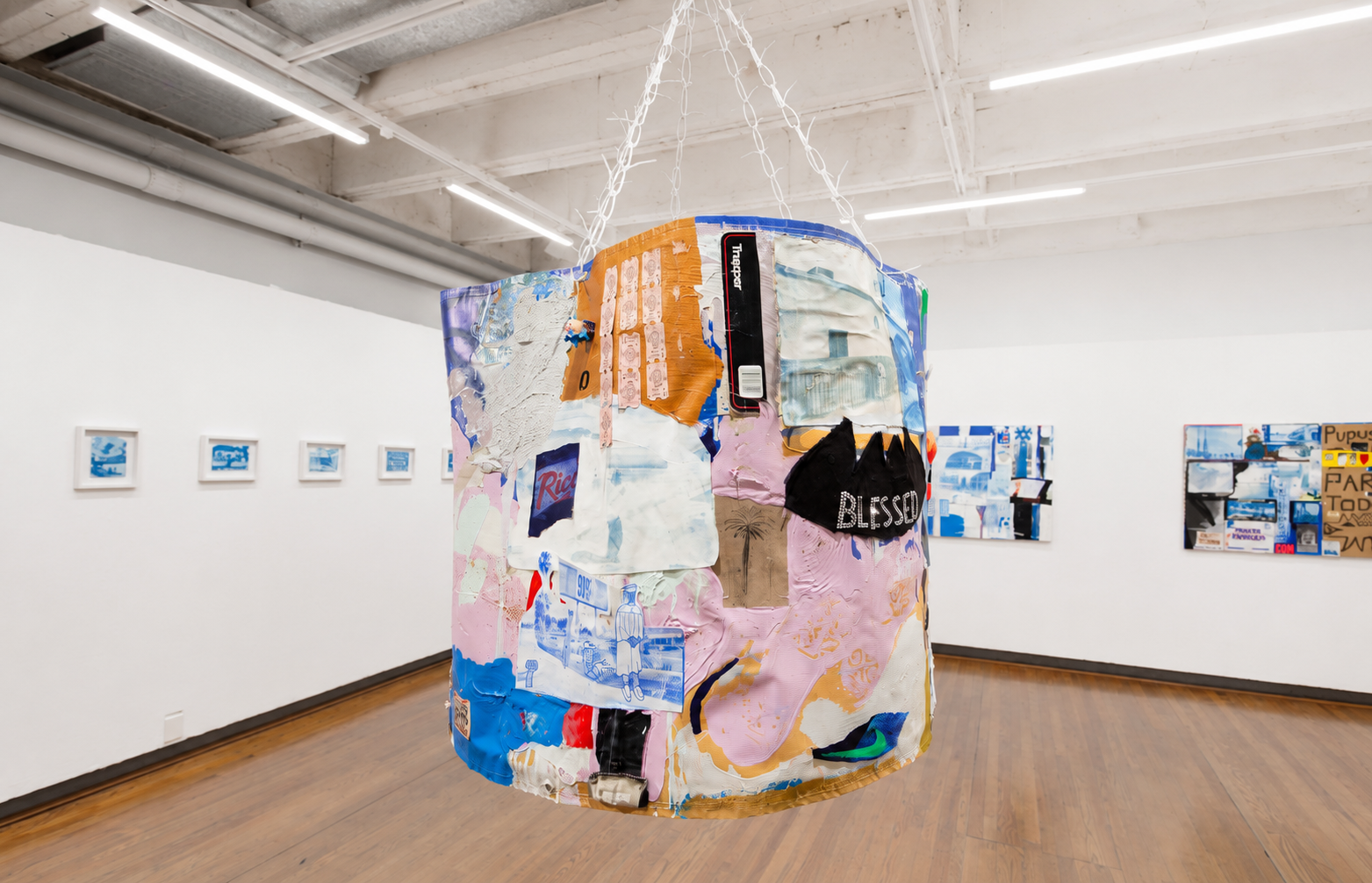 A large, colorful hanging artwork displayed prominently in an art gallery, showcasing abstract shapes and vibrant colors.