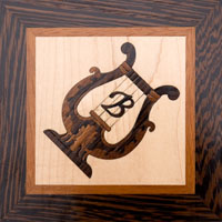 Inlaid wood lyre with script "B"