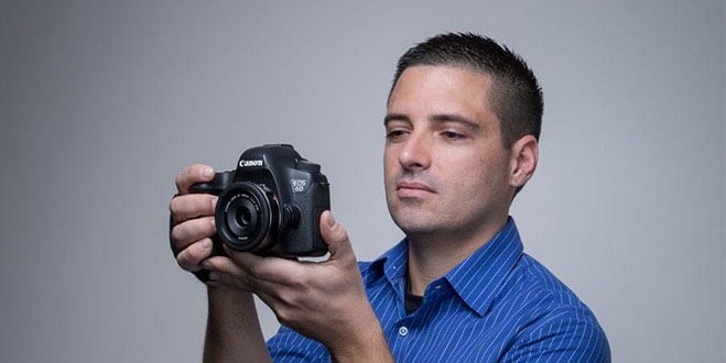 SJSU alumnus Dan Fenstermacher holds up a camera