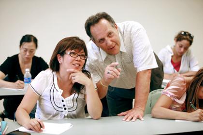 Instructor points forward beside a seated student