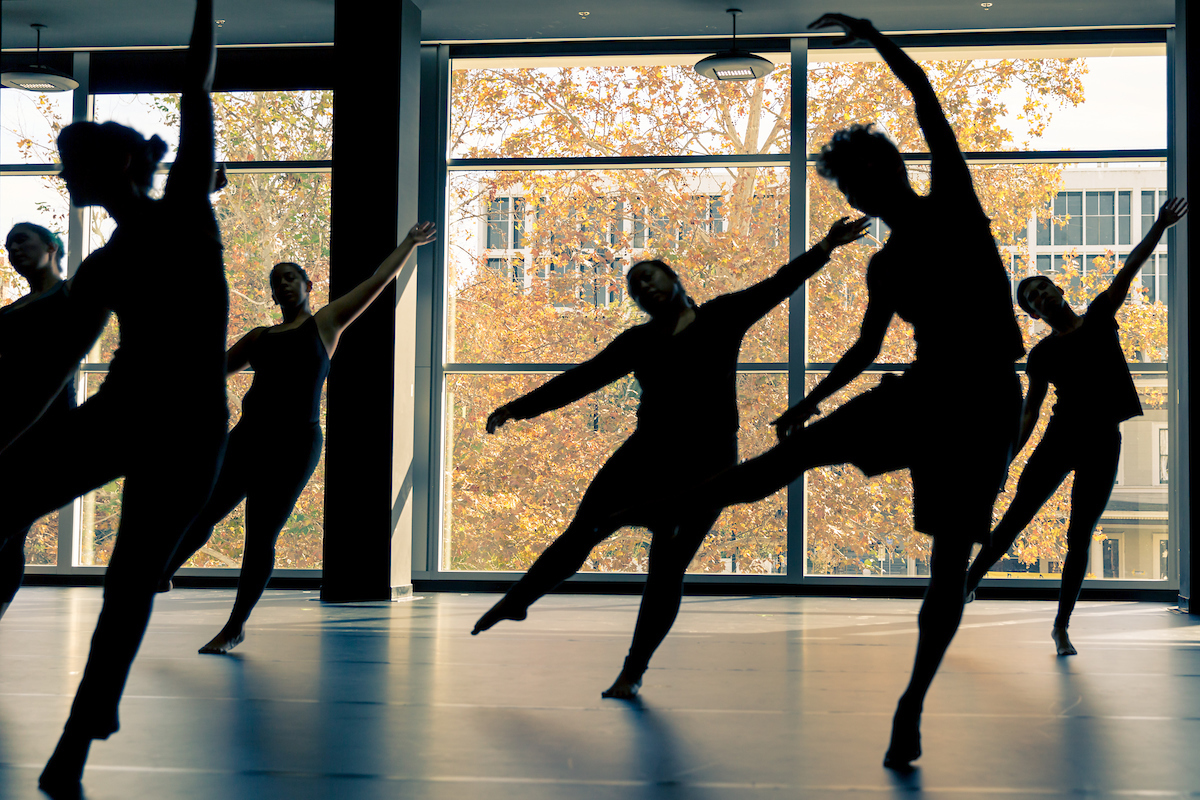 Silhouette of dancers practicing in a dance studio.