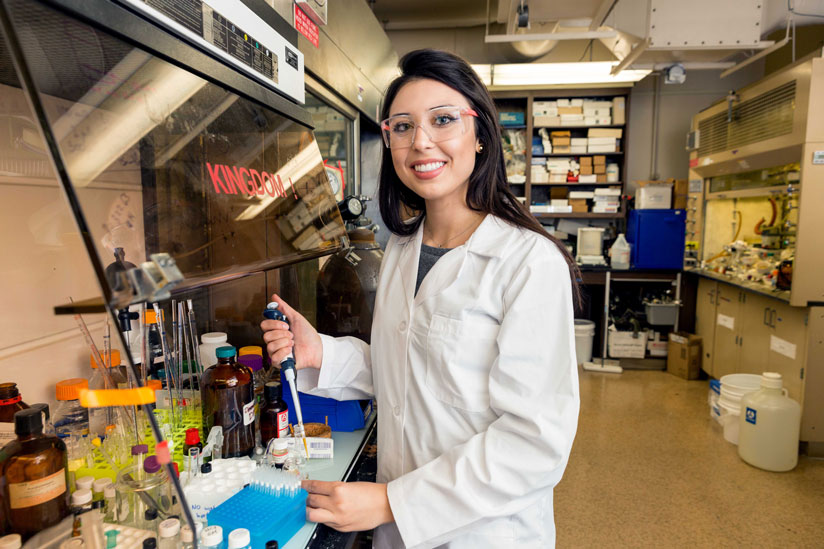 Female chemical engineernig student wearing lab gear and holding lab equipement