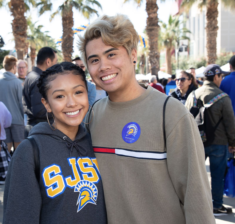 Two smiling students, a female and male, posing together.