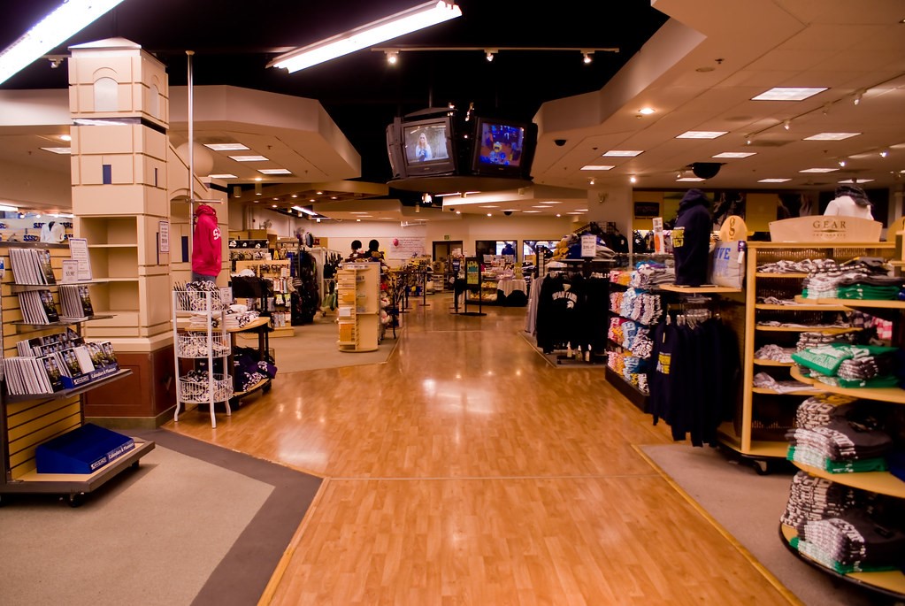 Inside the SJSU Spartan Bookstore, showing racks of clothes and notebooks
