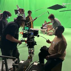 Hills of White Elephants production photo of actors and crew against a green screen.