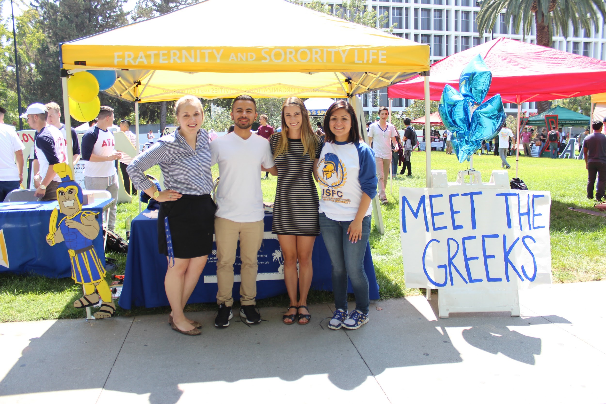 Group of students at a "Meet the Greeks" table in quad