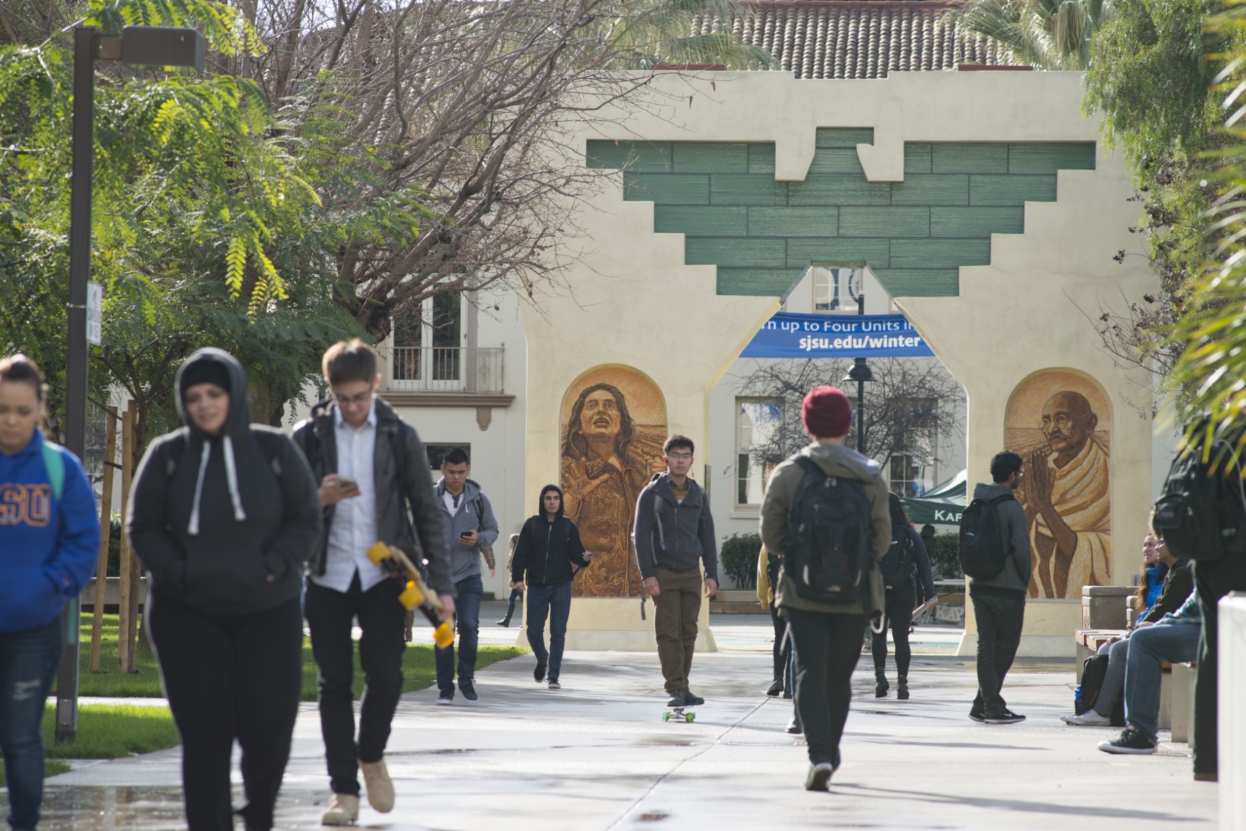Students walking past a full view of the Paseo archway