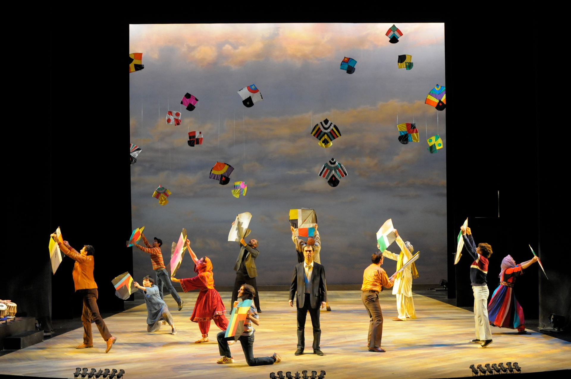 people on a stage holding kites