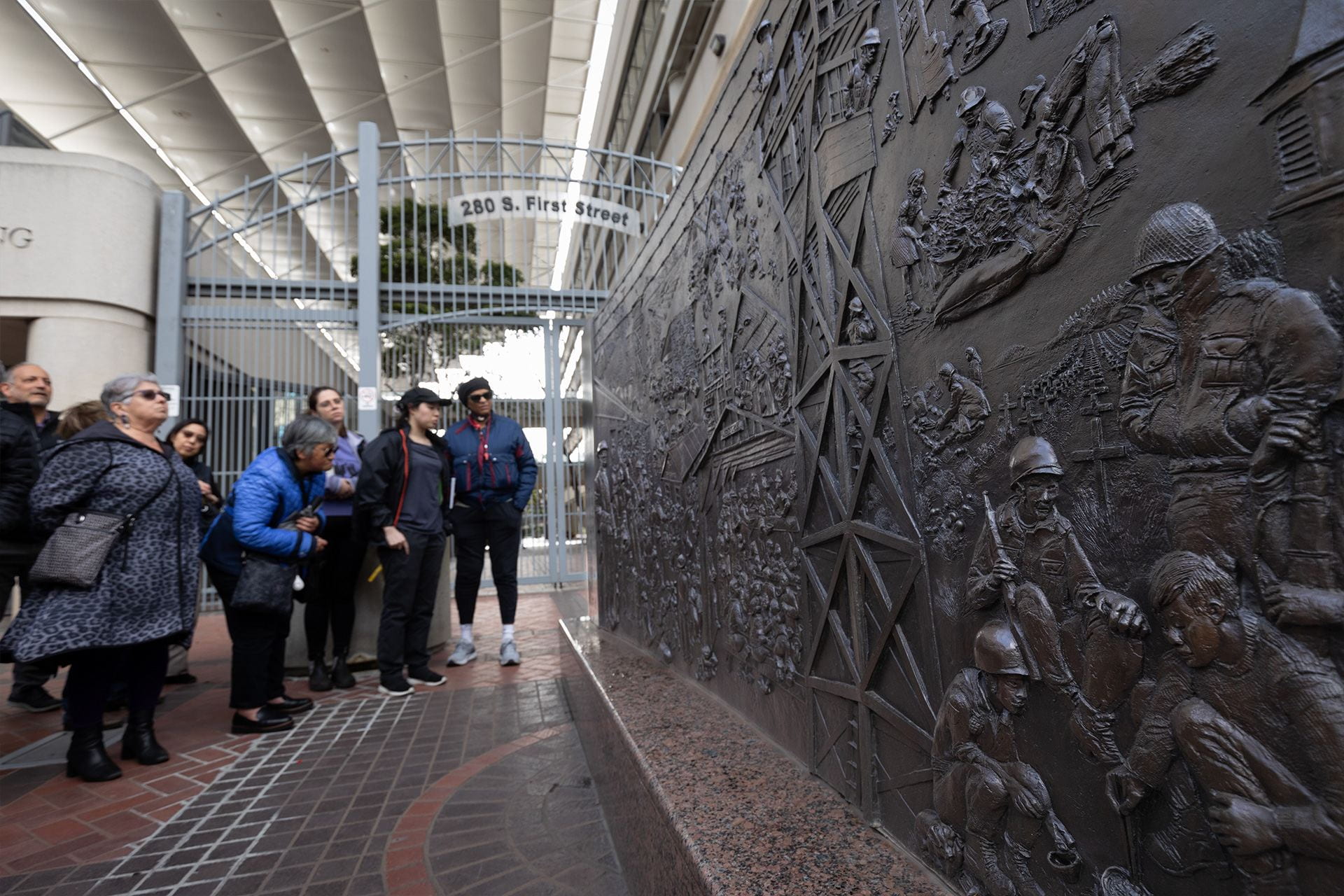 viewers gathered around ruth asawa bas relief statue during day of remembrance for the japanese american internment