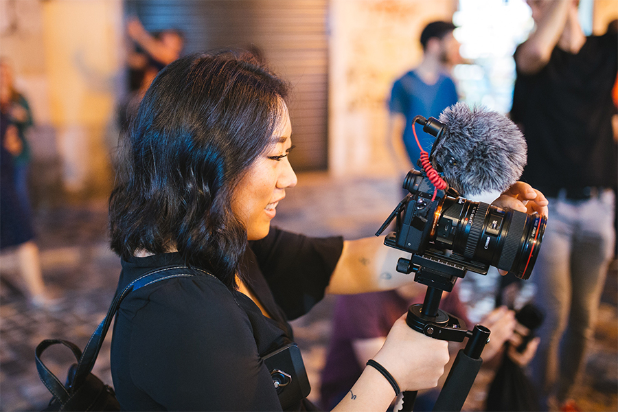 A female student films with a digital camera.