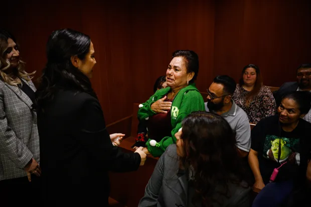 Adriana Vazquez-Chavez, a student assistant with the Record Clearance Project, holds hands before embracing Carmen Navarro, whose son was cleared of past convictions, at Family Justice Center in San Jose. (Shae Hammond/Bay Area News Group)