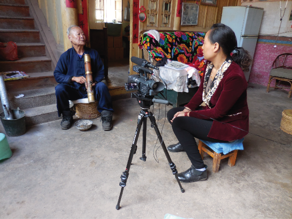 Woman interviewing older man on camera