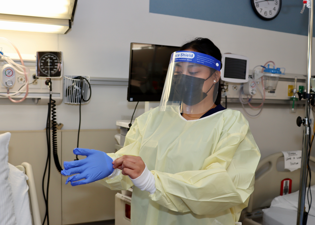 RN-BSN student demonstrates the donning of PPE.