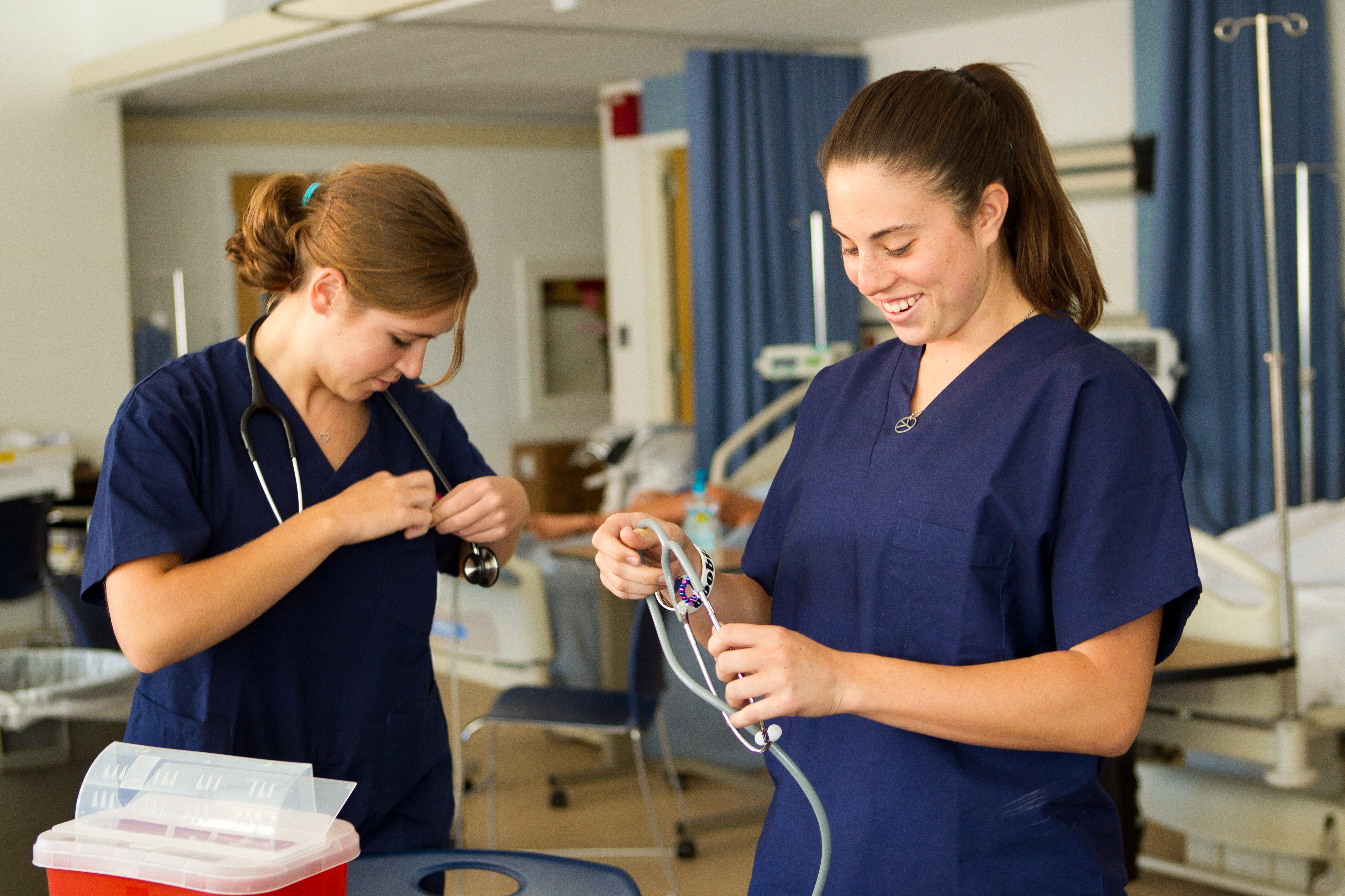 Two female nursing students prepare for class by gathering their tools.