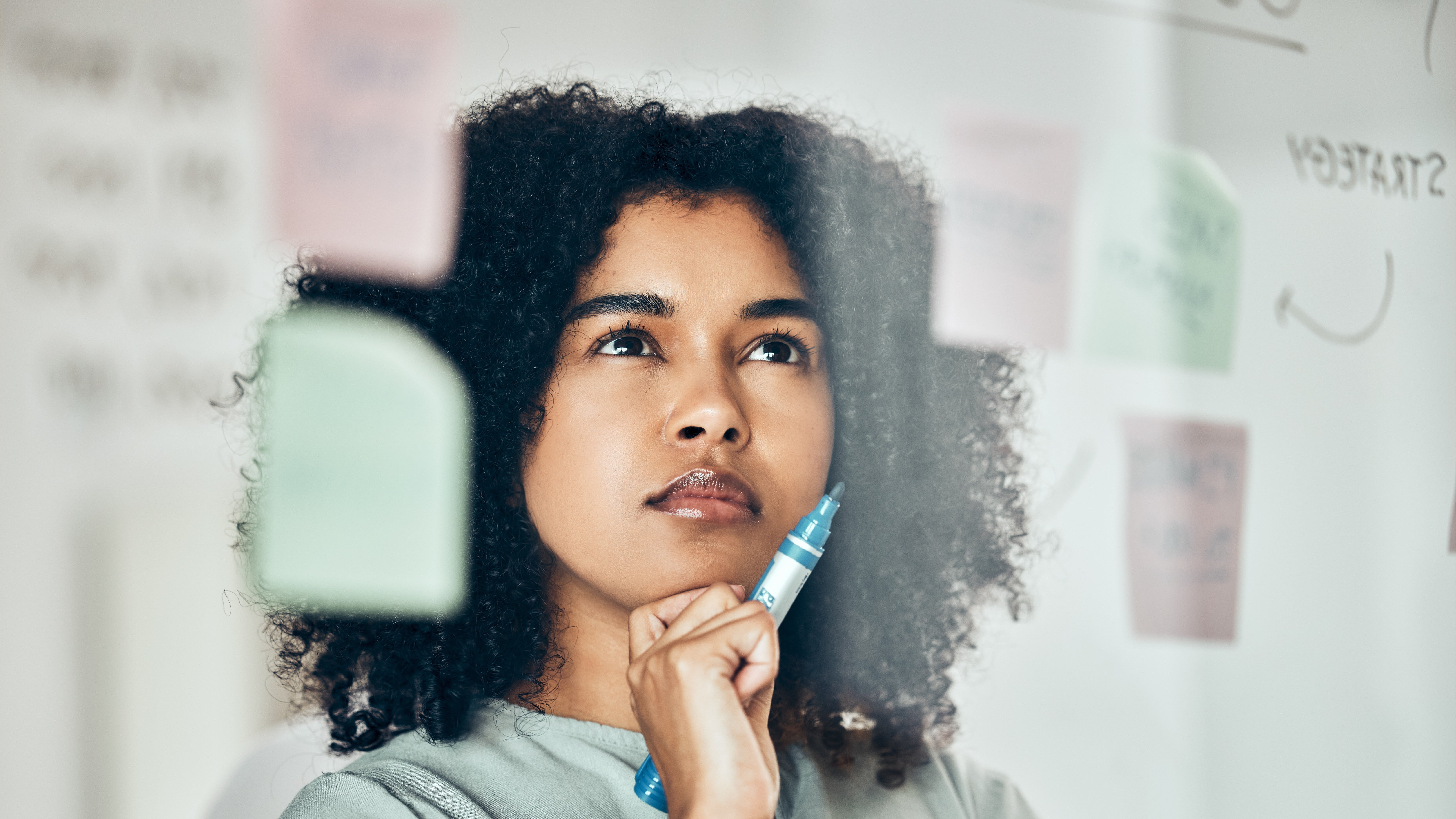 Woman thinking strategically while looking at a white board