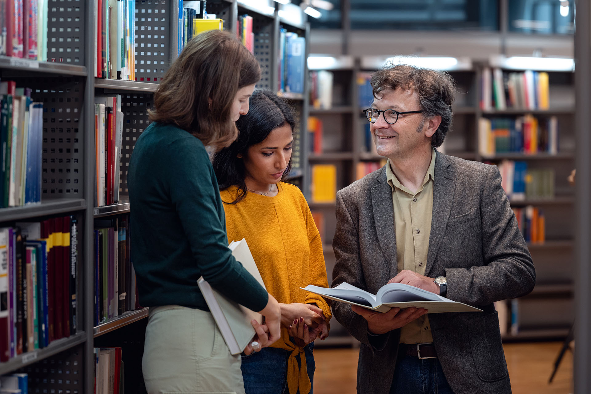 Male librarian assisting students