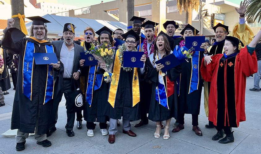 Group photo of graduates and faculty members in regalia.