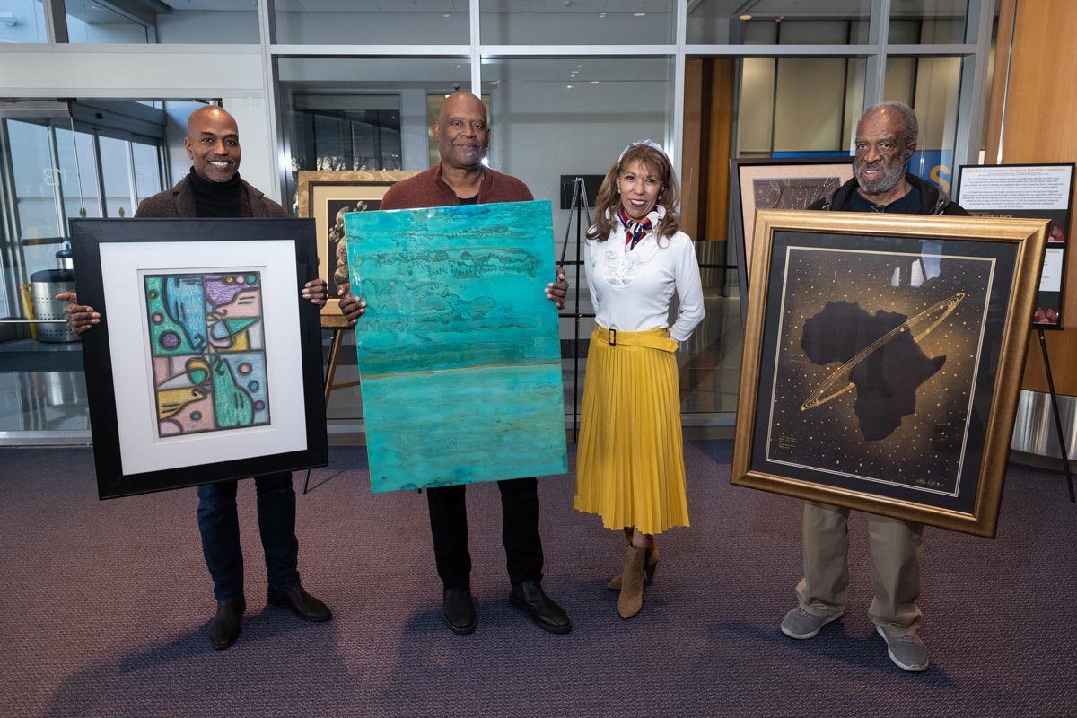 SJSU President posing with Black artists.