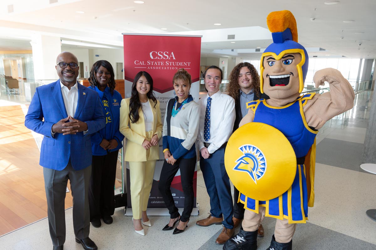 SJSU president posing with student government reps and Sammy Spartan.