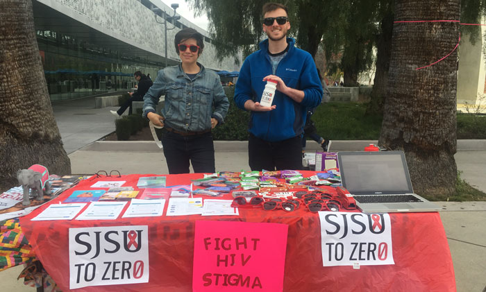 Two students tabling and providing HIV educational materials.