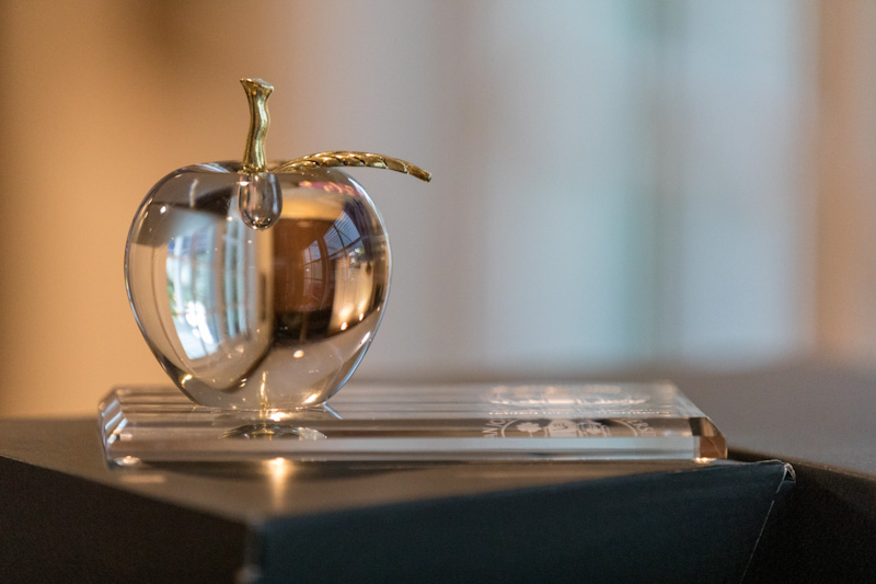 Glass apple award on a table.