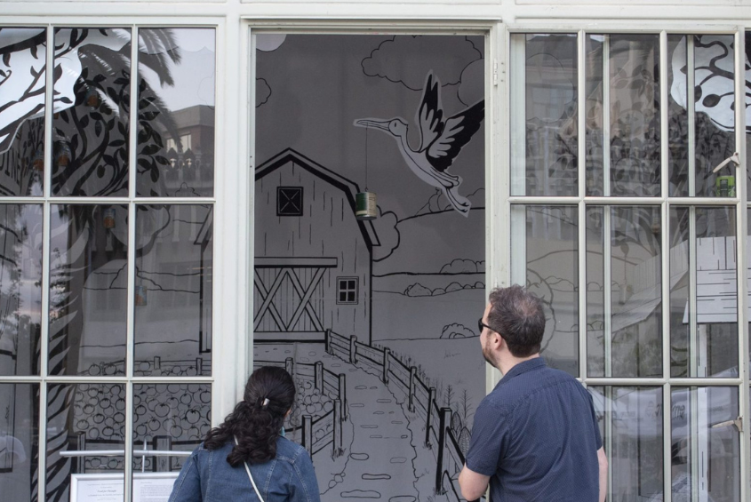 People looking at SJSU Student Artwork on display.