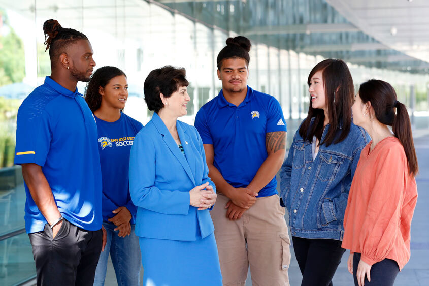 President Mary Papazian chatting with diverse students. 