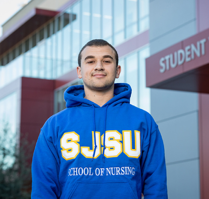 Male SJSU student in sweatshirt outside the Student Health Center